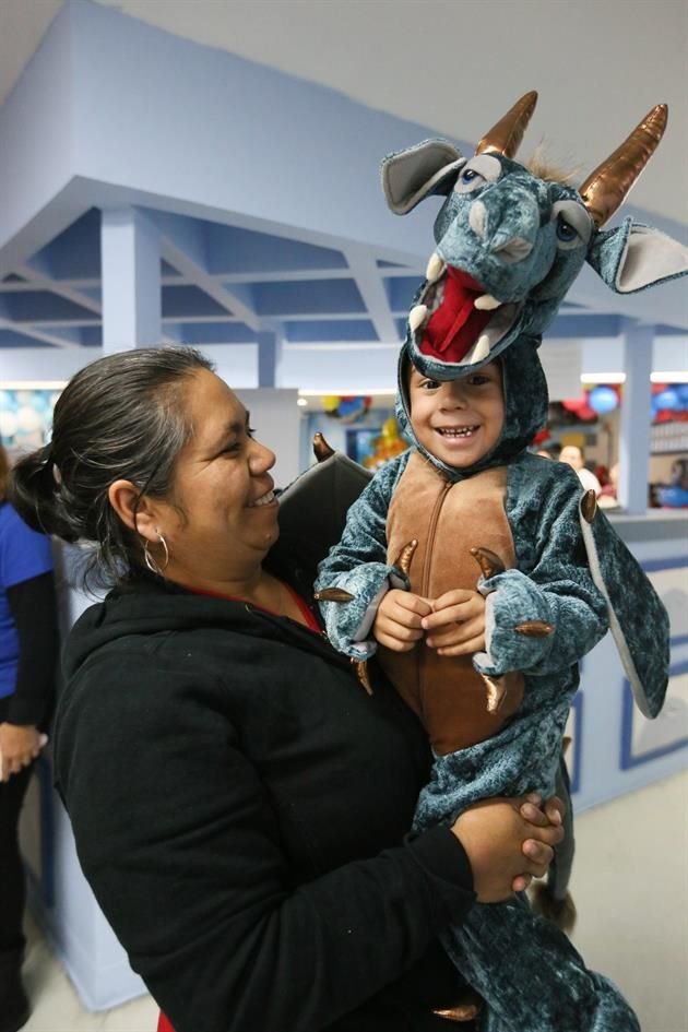 Belén Ayala García, abuela de Angel Daniel, le pone un traje de dragón que le fue entregado ayer previo a su consulta.