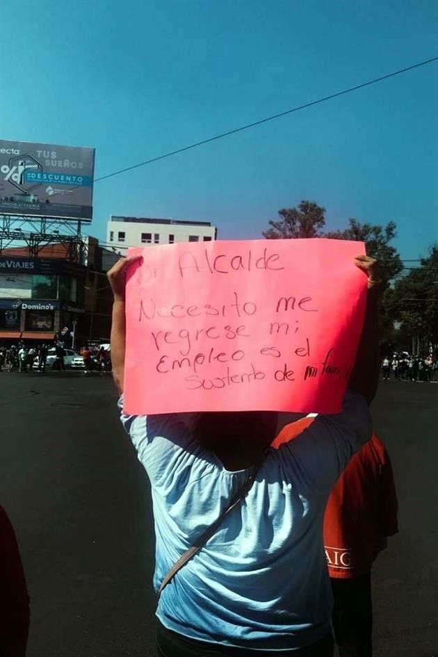 'Señor Alcalde, necesito me regrese mi empleo, es el sustento de mi familia', se puede leer en una pancarta que sostiene uno de los manifestantes.