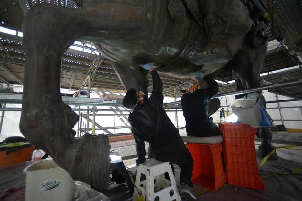 Con escalpelo en mano, los restauradores del INAH eliminan el recubrimiento negro de El Caballito para llegar a la pátina verde original.