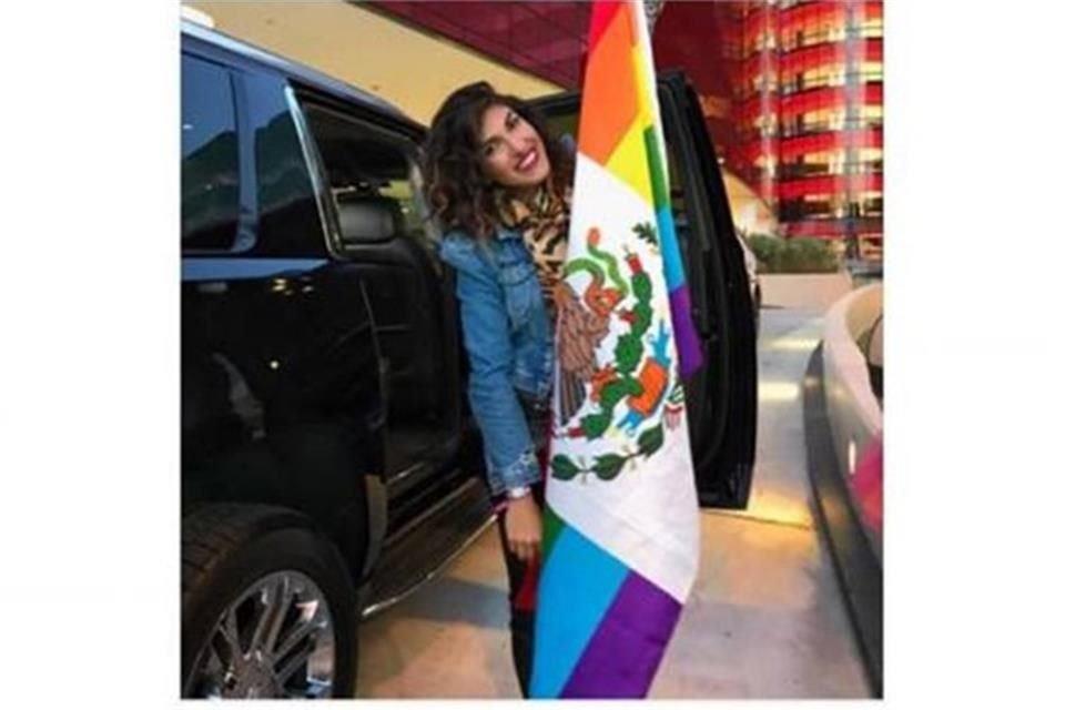 Posó con una bandera gay con el Escudo Nacional.