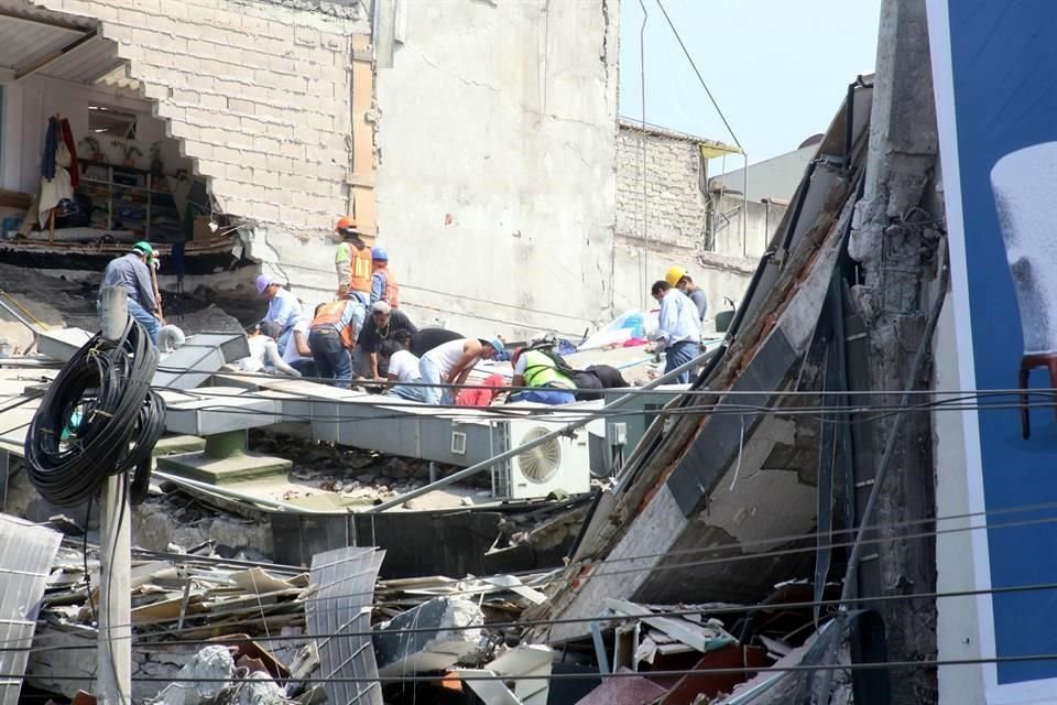 Trabajadores laboran entre los restos de una edificación de la calle Ámsterdam, en la Colonia Roma.