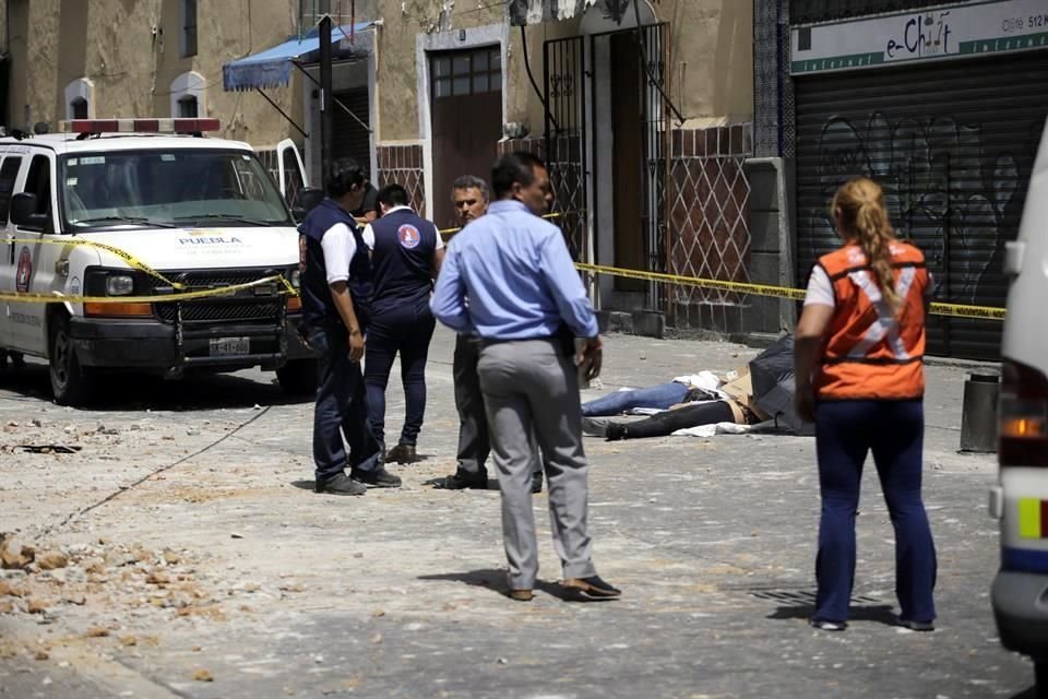 Socorristas levantan los cadáveres de dos personas en Puebla.