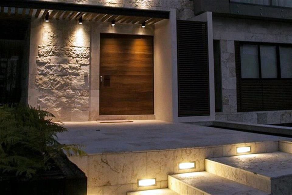 La luz en la entrada principal de una casa permite que las personas ubiquen el domicilio y destaca los detalles de su arquitectura.