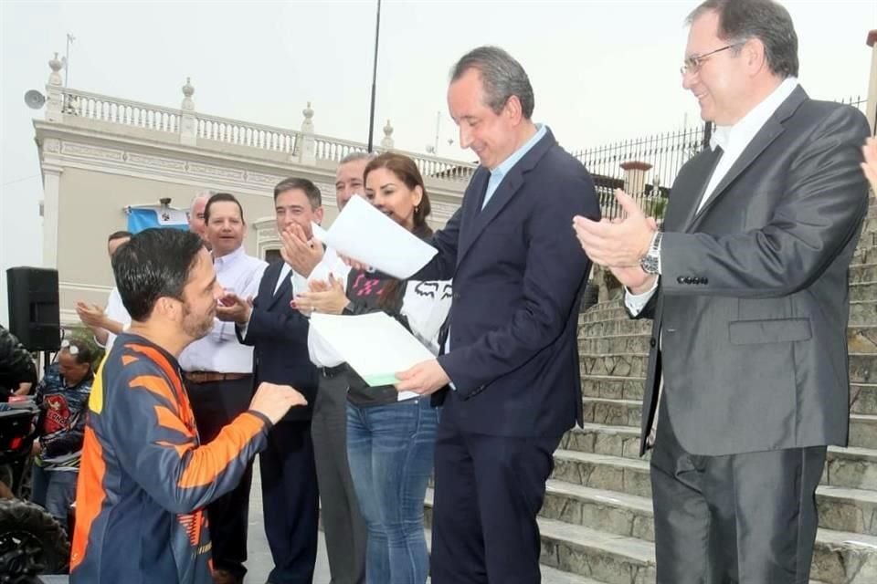Marco González, presidente del Congreso, coloca un placa a un RZR en el evento en la Plaza Principal de Santiago.