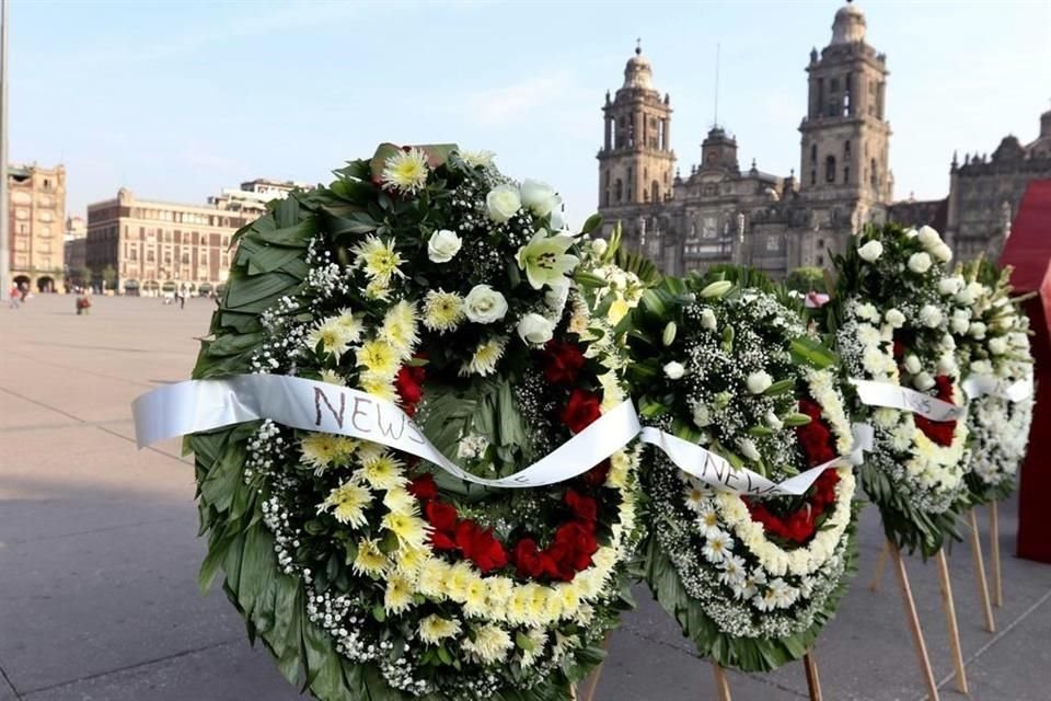 Integrantes de cinco familias colocaron frente a Palacio Nacional coronas fúnebres con la leyenda 'News Divine' y veladoras.