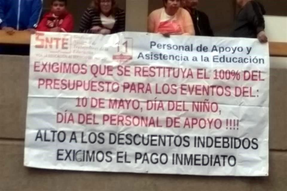 Los manifestantes, algunos con playeras distintivas de la sección, siguen en la explanada del primer piso con pancartas y cartulinas.