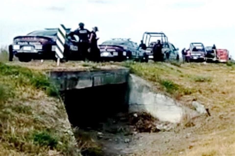 Policías estatales y federales custodian la zona donde fue encontrado el ejecutado, en la Carretera a Reynosa.