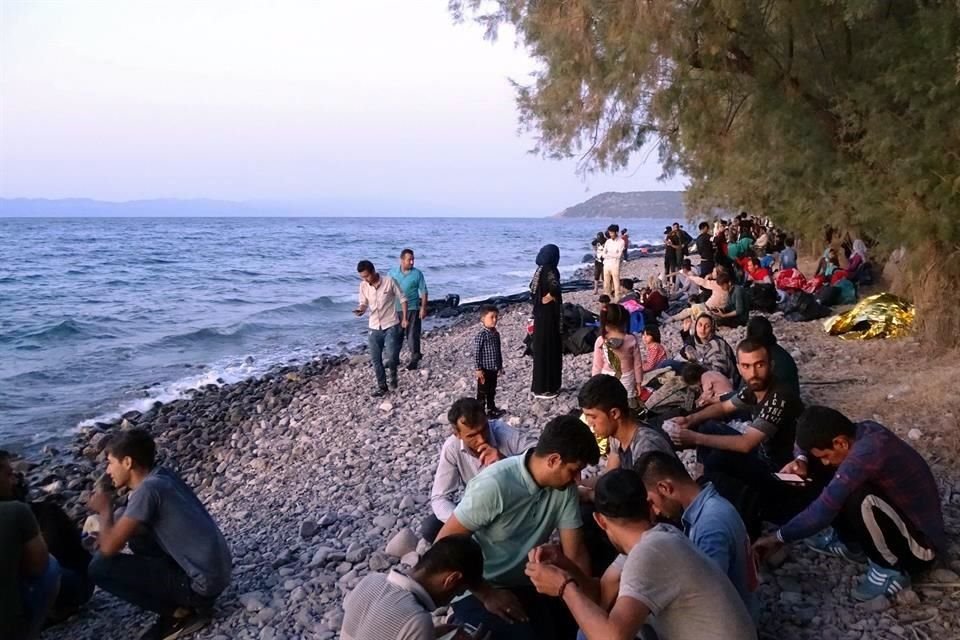 Migrantes que llegaron a Grecia en 13 barcos esperan en la costa de Skala Sikaminia.