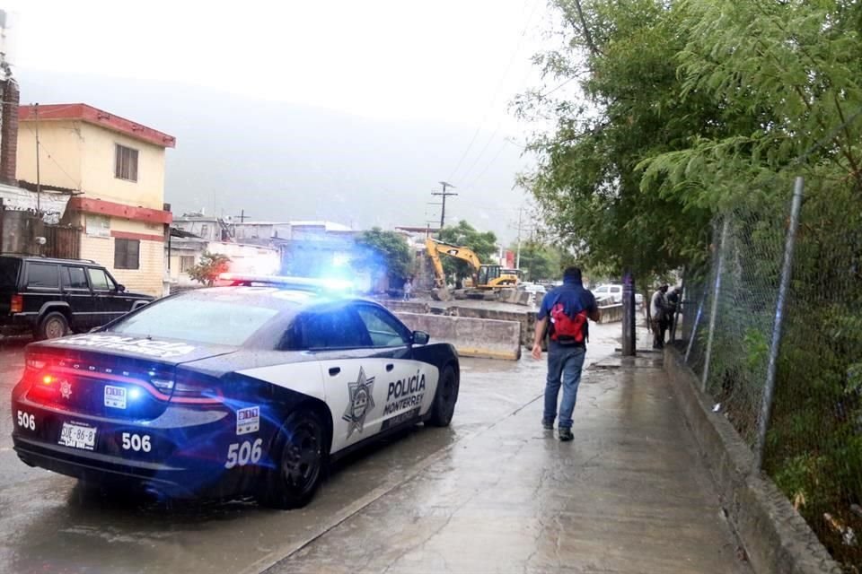 Una patrulla vigila una obra pluvial en la Col. Valle Santa Lucía, a cargo del Municipio de Monterrey, donde varios vehículos han sido arrastrados por el agua.