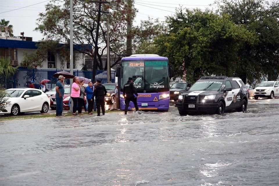 Pasajeros de transporte urbano tratan de ponerse a salvo en la Avenida Bernardo Reyes.