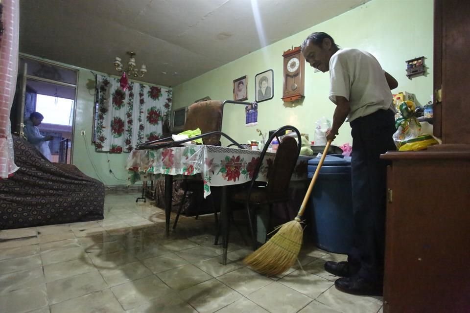 Un habitante de la Colonia Las Puentes 4 Sector, saca el agua tras inundarse su casa.