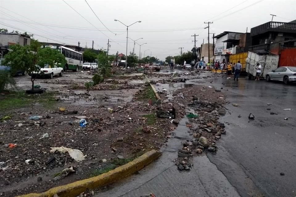 Vecinos salieron a la Avenida Camino Real, la cual lucía un panorama desolador con el pavimento levantado, con corrientes de agua provenientes del Cerro del Topo Chico y un alud de rocas y lodo.