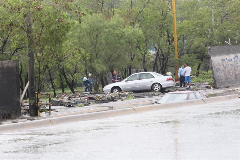 Al bajar el nivel del agua<br>de la Colonia Lázaro Cárdenas quedaron al descubierto baches y autos que quedaron varados.