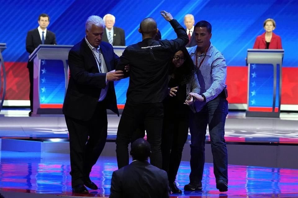 Manifestantes que pedían a los candidatos defender el programa DACA entraron al escenario y fueron sacados.