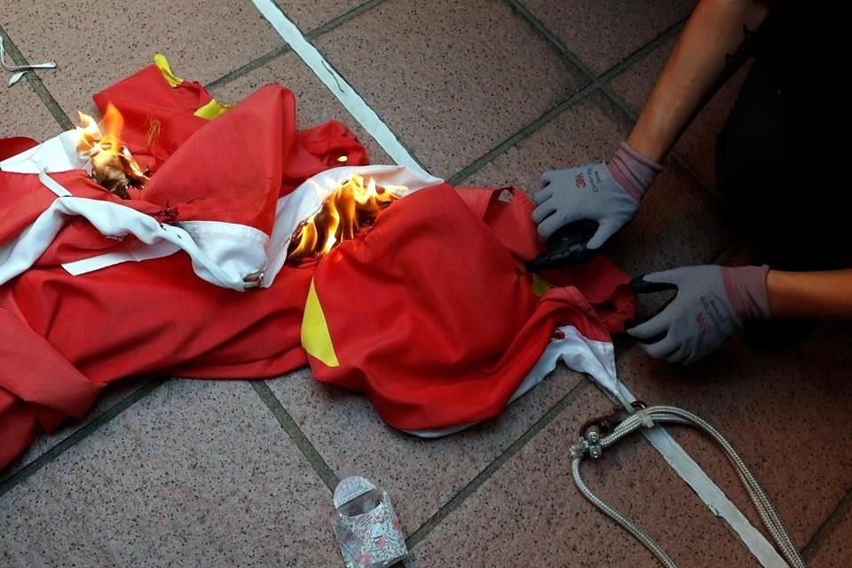 Lo manifestantes tiraron la bandera y le prendieron fuego.