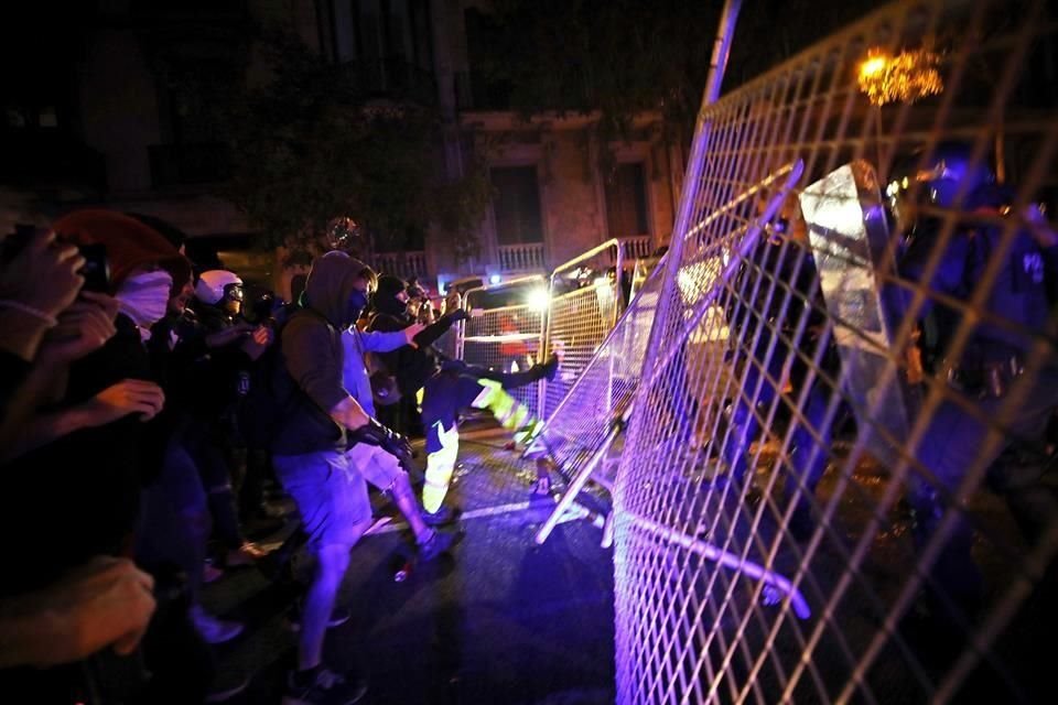 Manifestantes tiran una reja frente a la sede del Gobierno español en Barcelona.