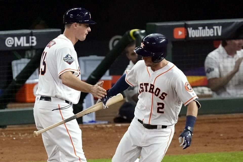 Alex Bregman le entrega al coach Don Kelly su bat después de pegar un jonrón en el primer inning, anoche.