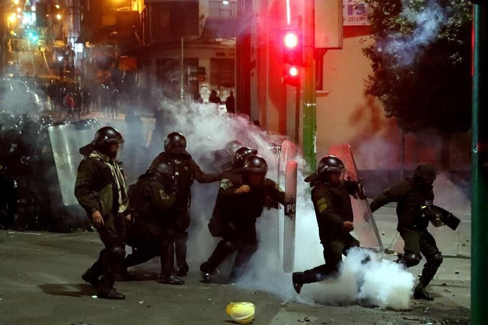 Policías intentan replegar a manifestantes el martes por la noche.