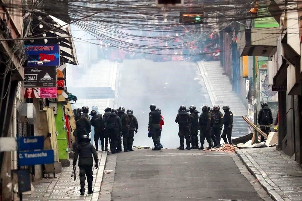 Fuerzas de seguridad bloquean un camino frente a manifestantes.