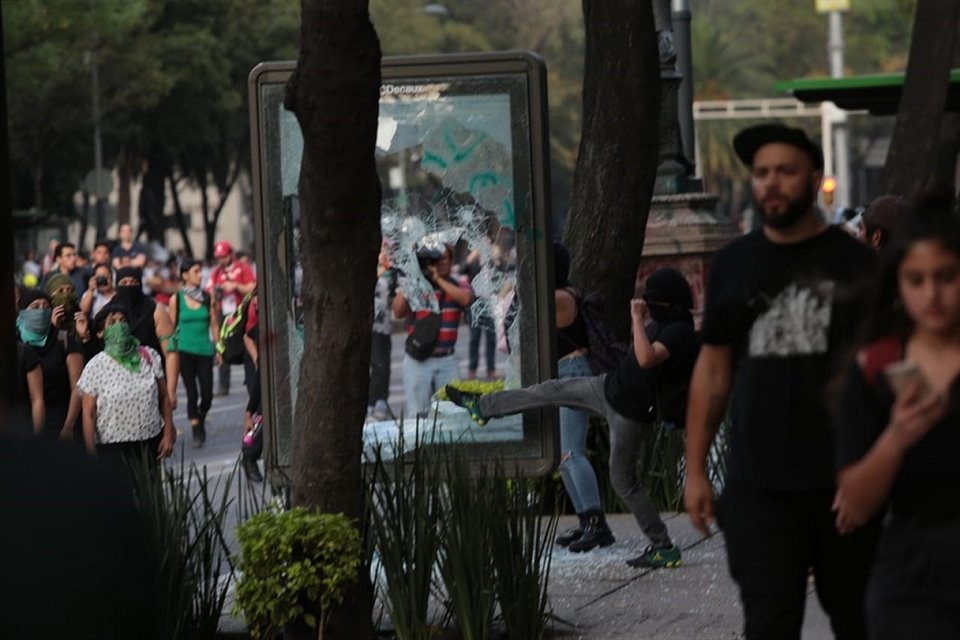 Una mujer rompe el cristal de una estación del Metrobús, en el Ángel de la Independencia.