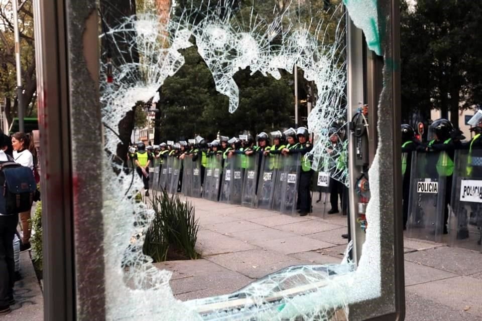 Algunas encapuchadas realizaron destrozos en los vidrios de los parabuses de la línea 7, a la par que uniformadas las vigilan.