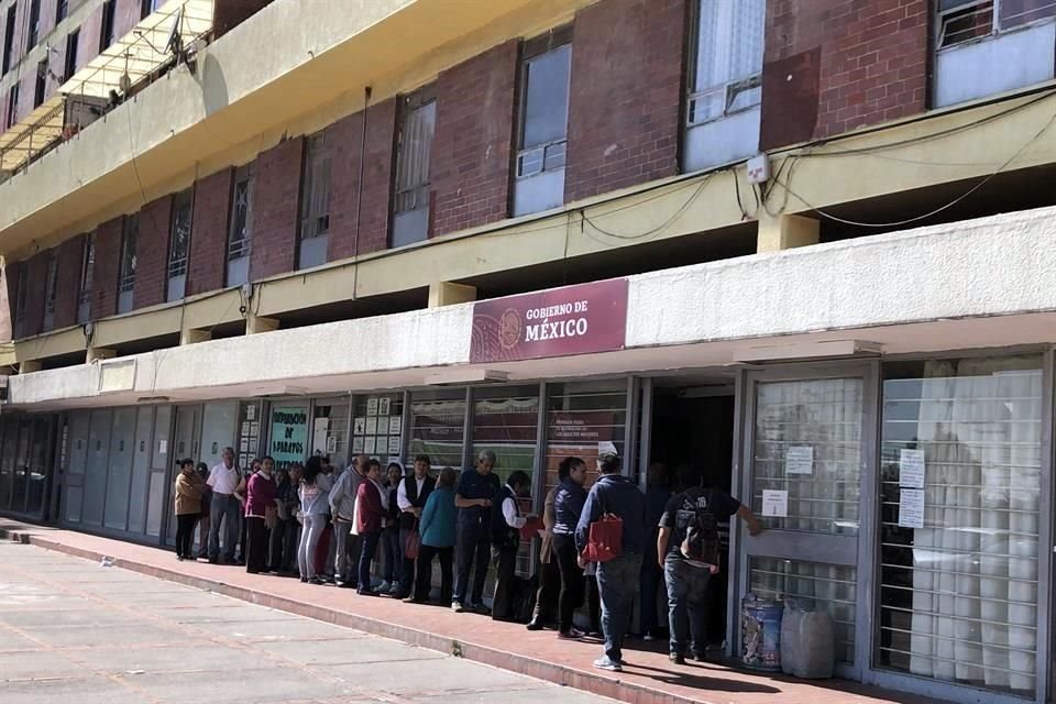 En silla de ruedas o con bastón, hombres y mujeres deben esperar de pie a que la fila avance para poder entrar al local y exponer su problemática.