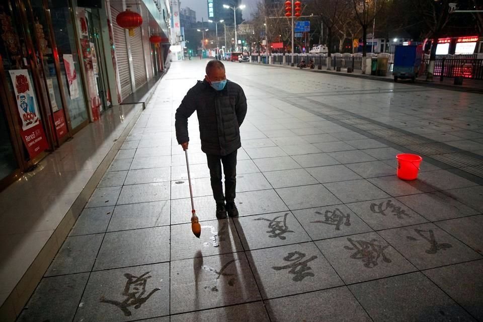 Un hombre practica caligrafía en las calles de Jiujiang, en China, en medio del freno de actividades por el brote de coronavirus.