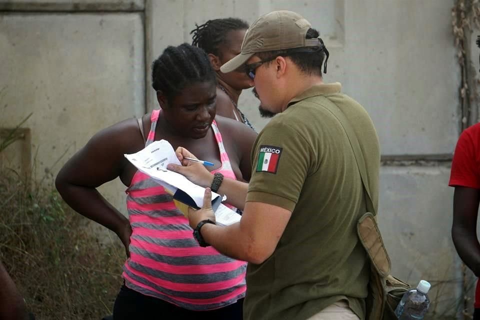 Un agente de Migración con una mujer haitiana en un punto fronterizo en Tapachula, Chiapas.