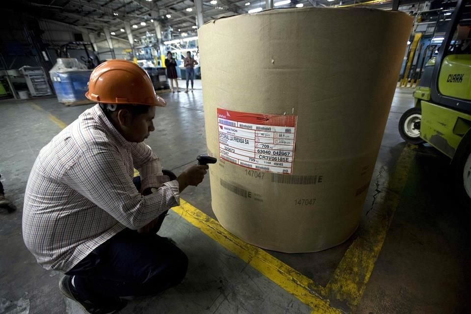El jefe de inventario del diario La Prensa revisa el código de serie de una bobina de papel en Managua.