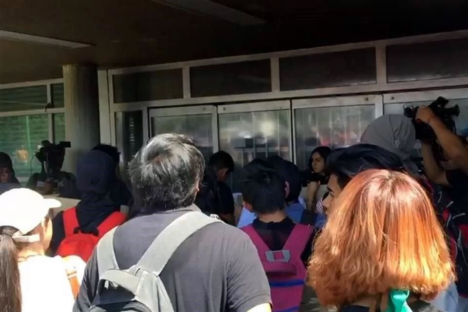 Los participantes en la marcha afuera de la entrada del edificio.