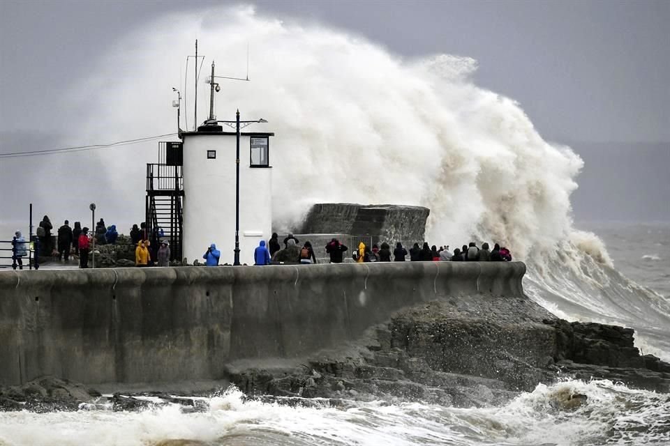 Grupos de personas observan las olas en Gales.