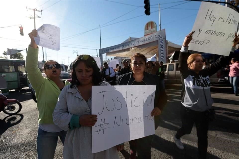 Los padres de familia portan pancartas en demanda de justicia.