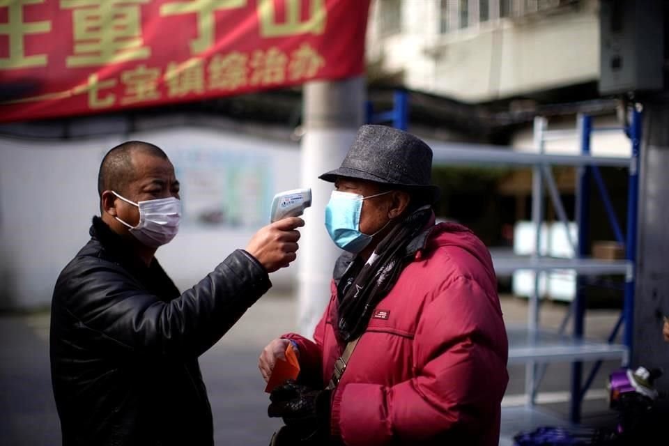 Un hombre revisa la temperatura en la calle en Qibao, una ciudad en las afueras de Shangai, China.