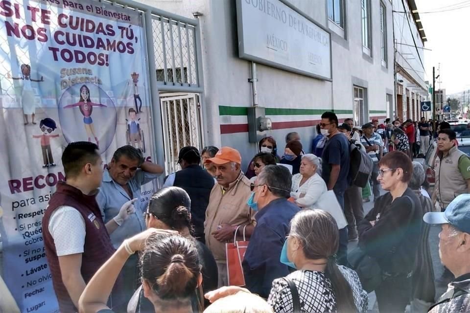 Adultos mayores y familiares reunidos afuera de la delegación de la Secretaría del Bienestar en Pachuca, Hidalgo.