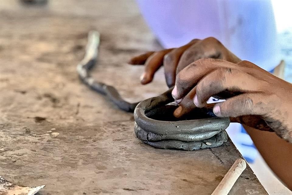 Alumnos de la telesecundaria de San José Manialtepec, en el taller de barro.