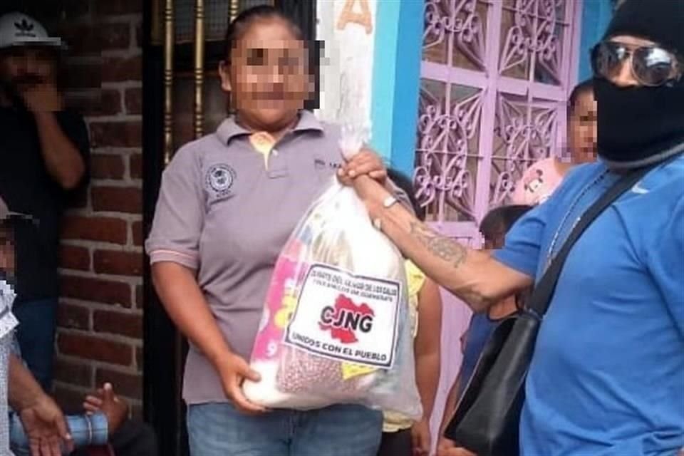 Los supuestos sicarios, con pasamontañas y armas largas, repartieron los paquetes de alimento y productos de higiene en la zona oeste de la entidad, según lo expuesto en redes sociales.