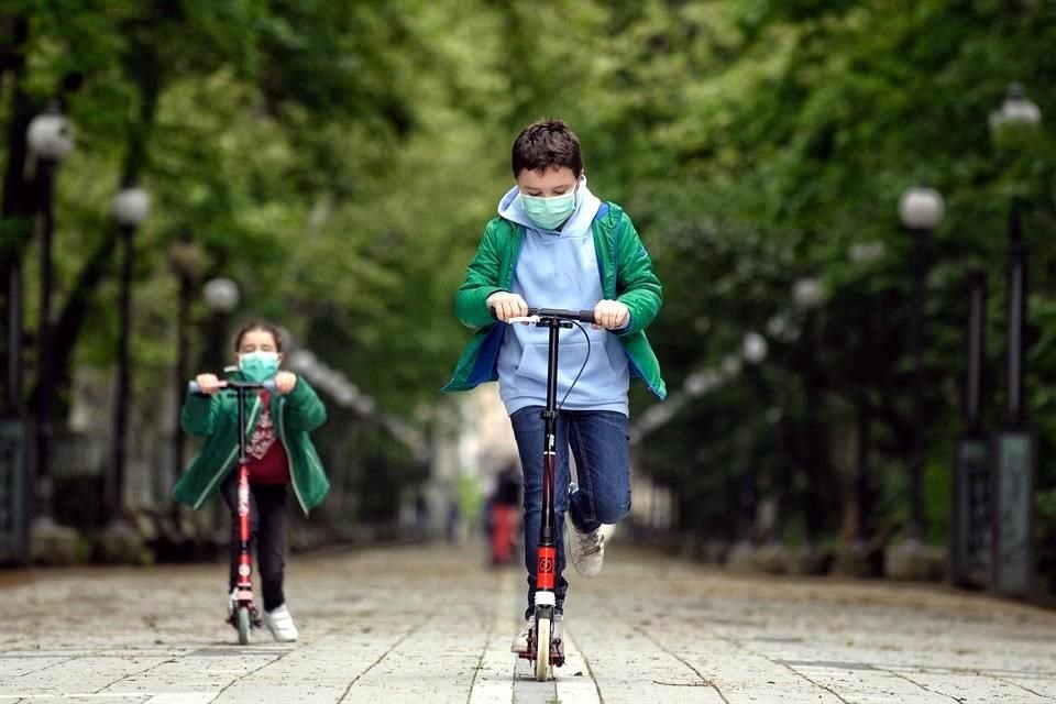 Dos niños recorren con sus patines un parque de Valladolid, durante el primer día en el que los menores pueden salir a la calle acompañados de un adulto.