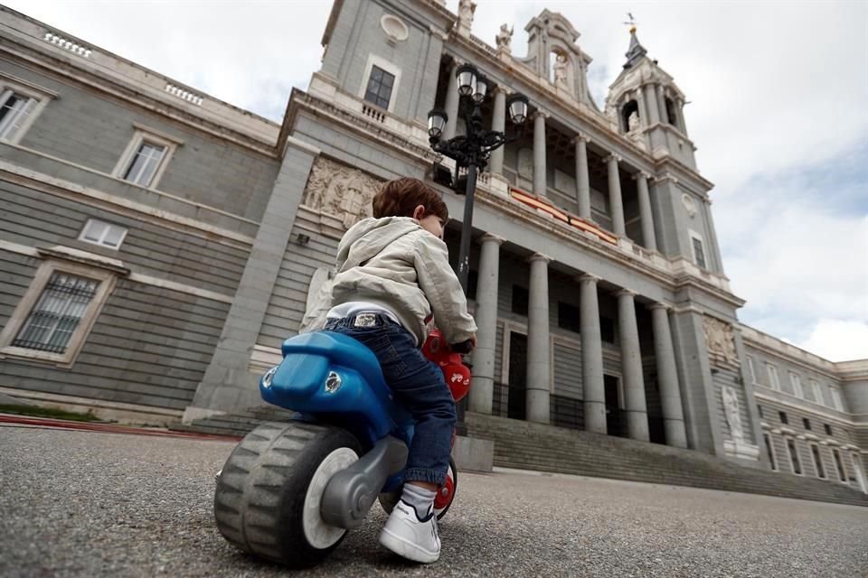 Un menor juega ante el Palacio Real, en Madrid, este domingo en el que se cumplen 44 días de confinamiento en España.