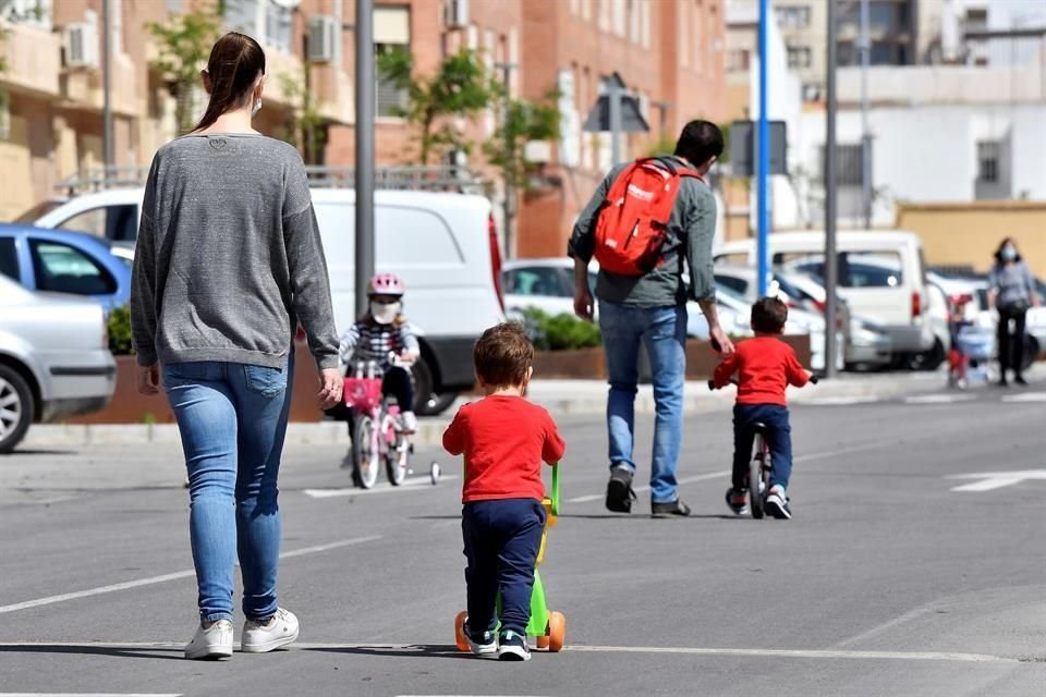 Varios menores pasean por Almería acompañados de un adulto, a más de un mes de confinamiento en España por el Covid-19.