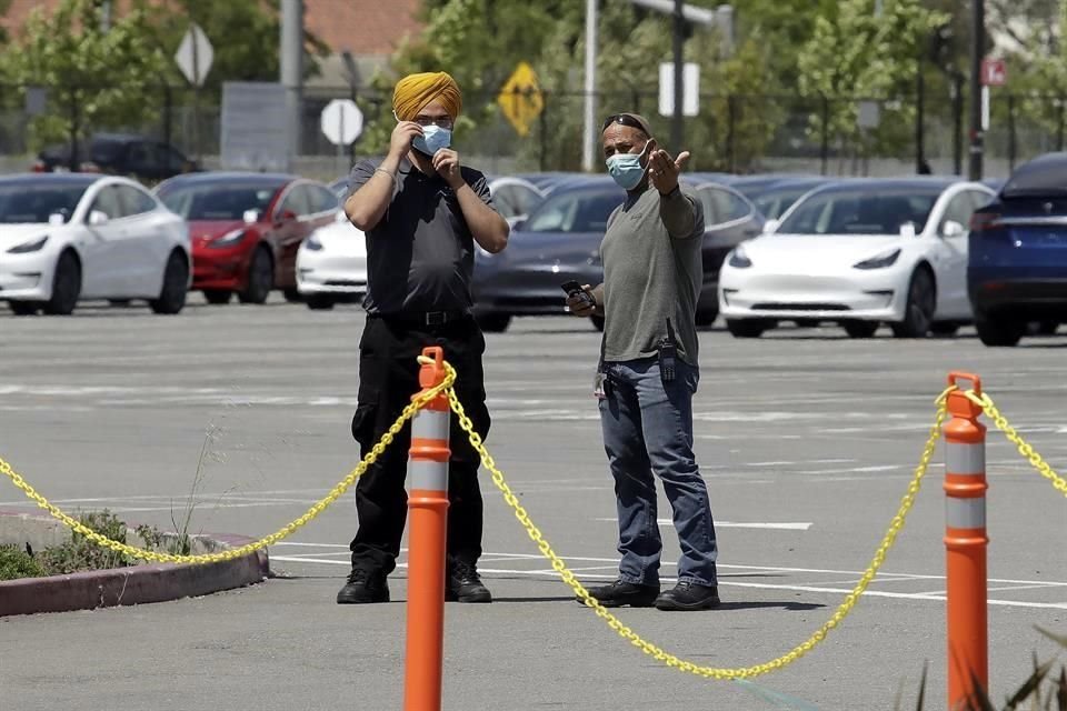 Personal resguarda los autos nuevos estacionados en la planta de Fremont, California.