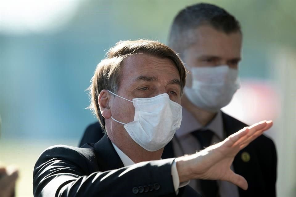 El Presidente de Brasil, Jair Bolsonaro (d), sale este lunes, del Palacio do Alvorada, sede de la Presidencia, en Brasilia.