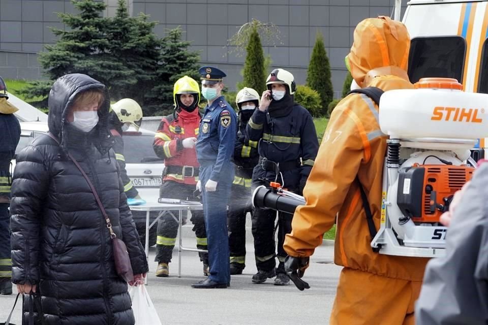 Personal de emergencia desinfecta a personas en un hospital mientras se atiende un incendio en Sas Petersburgo, Rusia.