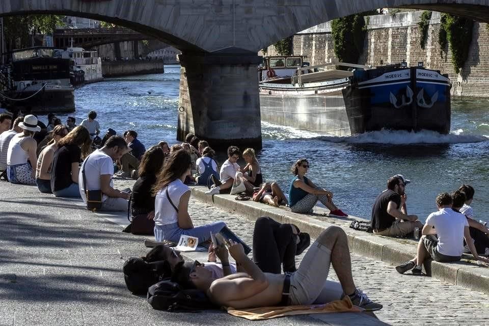 Ciudadanos de París descansan junto al Río Sena luego de dos meses de cuarentena por la pandemia.