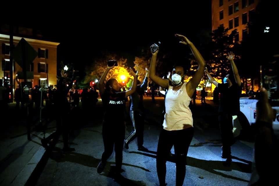 Varios manifestantes caminaron con los brazos alzados a modo de protesta por asesinato de George Floyd.