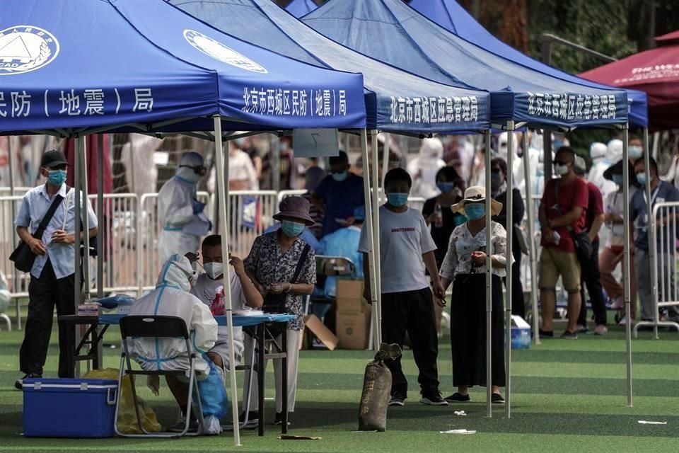 Residentes o gente que visitó el mercado de Xinfadi hacen cola para hacerse el test de coronavirus en el pabellón deportivo de Guang'an en Beijing.