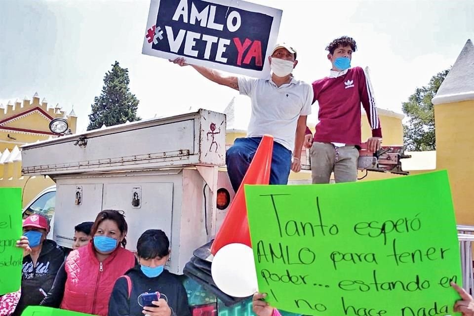 Entre gritos de reclamo, le muestran cartulinas verdes con leyendas como 'AMLO, vete ya'.