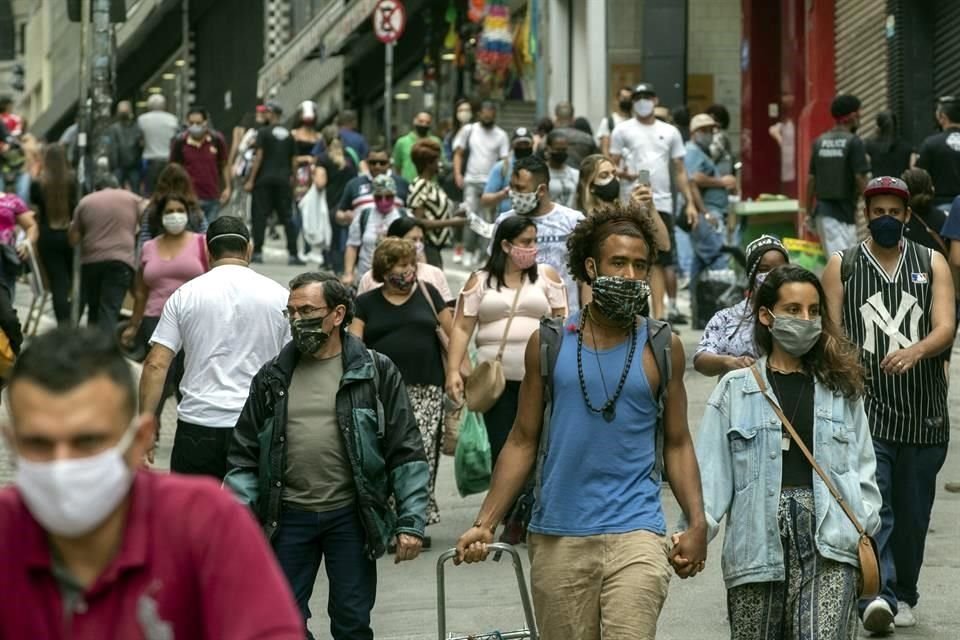 Personas con cubrebocas caminan por un distrito de compras Sao Paulo, Brasil.