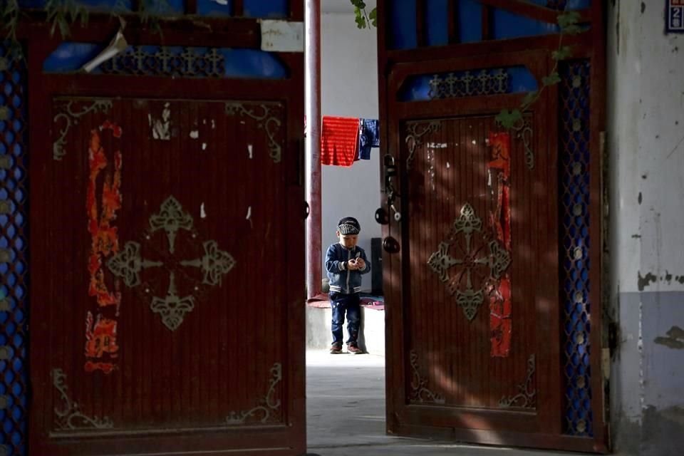 Un niño uigur juega en un patio en Hotan, China. Organizaciones han denunciado la persecución de esta minoría musulmana por parte del Gobierno chino.+