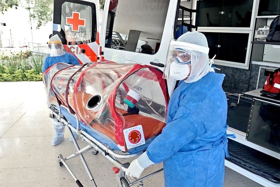 La paramédica Diana Ortiz (izq.) y el operador Edgar Elizondo usan una cápsula para trasladar a pacientes con Covid-19.