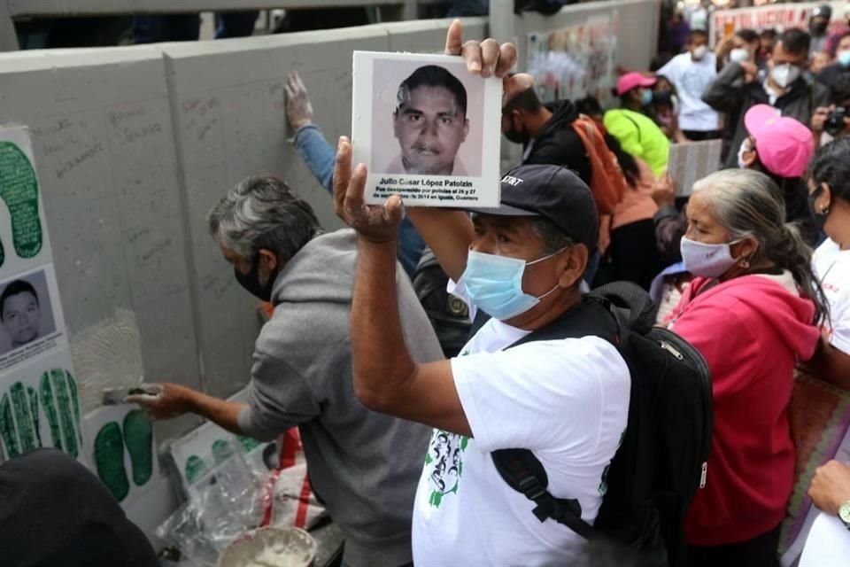 Junto a los retratos se colocó unas huellas de los familiares que buscan a los normalistas.